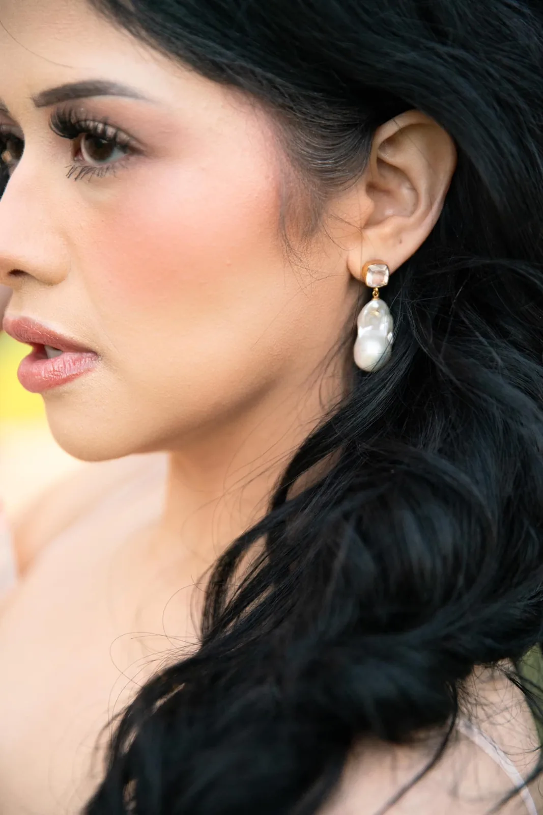 Profile of a bride with luminous skin, defined brows and long dark curls