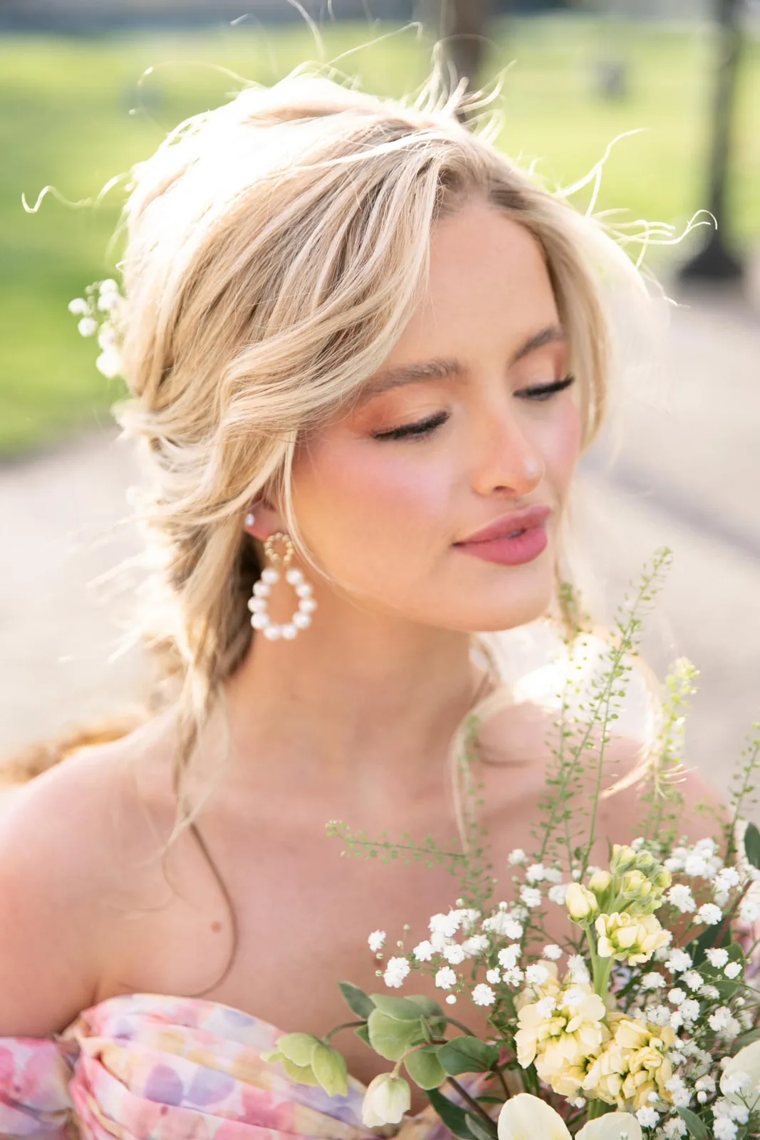 Close-up of a bride with soft pink glam makeup and a braided updo